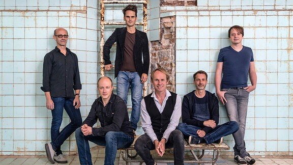 Die Band Keimzeit, bestehend aus sechs männlichen Mitgliedern, posiert für die Kamera.