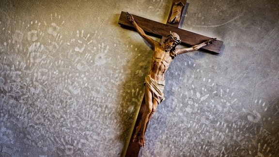 Neben dem Kreuz sieht man die Handabdrücke der Gläubigen an der verrußten Kirchenwand. Siegsdorf Bayern Deutschland 