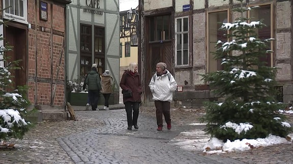 Menschen schlendern durch ein verschneites Quedlinburg