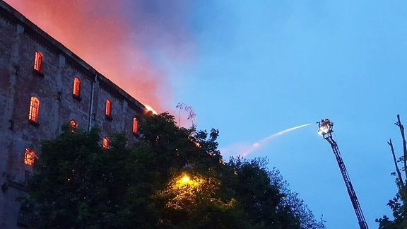 Die Feuerwehr bei Löscharbeiten an einem brennenden Haus