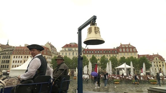 Eine Glocke hängt an einer Kutsche.