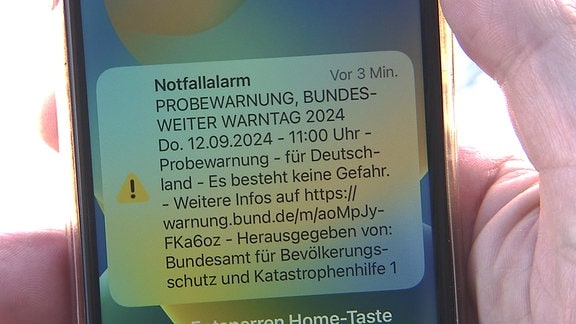 Auf einem Telefonbildschirm wird eine Nachricht zu einem Notfallalarm angezeigt.