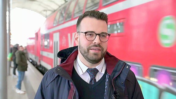 Lokführer vor einer S-Bahn im Interview