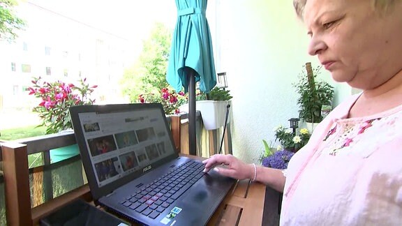 Frau sitzt vor einem Laptop.