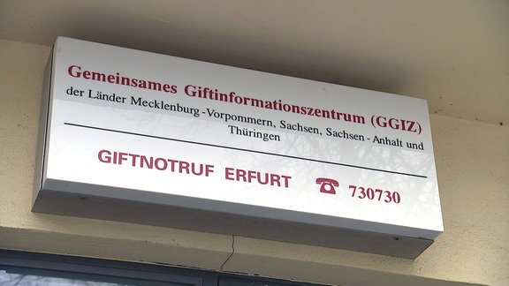 Schild Giftnotruf Erfurt Telefon 730730 über einem Hauseingang.
