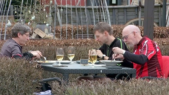 Menschen speisen auf dem Freisitz eines Restaurants.