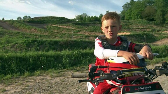 Luca sitzt auf seinem Motorrad und beantwortet Fragen.