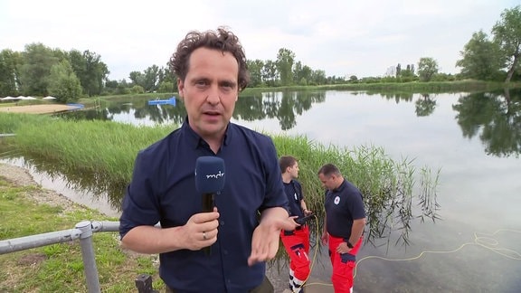 Reporter Stefan Ganß sthet an einem See.