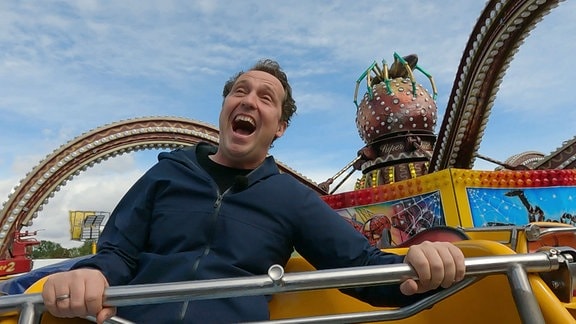 Stefan Ganß in einem Fahrgeschäft.