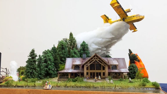 Ein Modell von einem Löschflugzeug über einem Haus