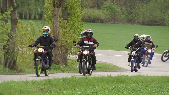 Eine Gruppe Mopedfahrer auf der Straße