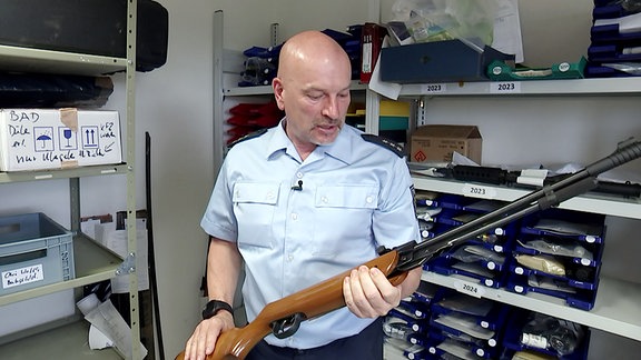 Polizist zeigt Gewehr in der Asservatenkammer der Bundespolizei