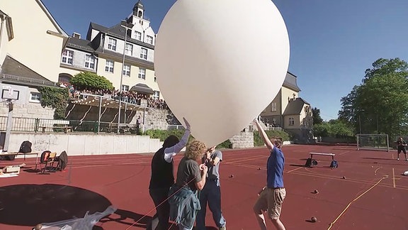 Schüler lassen einen Ballon steigen.