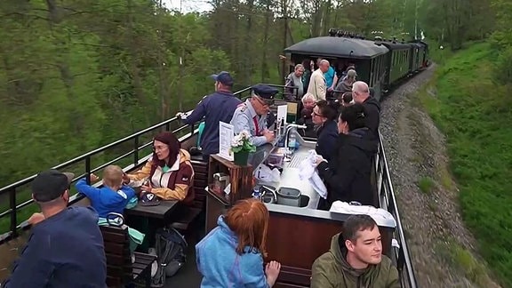 Passagiere sitzen im offenen Speisewagen der Pressnitztalbahn