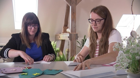 zwei Frauen schreiben Postkarten