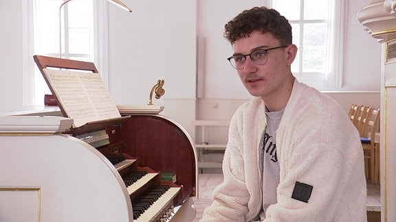 Ein junger Mann an einer Orgel