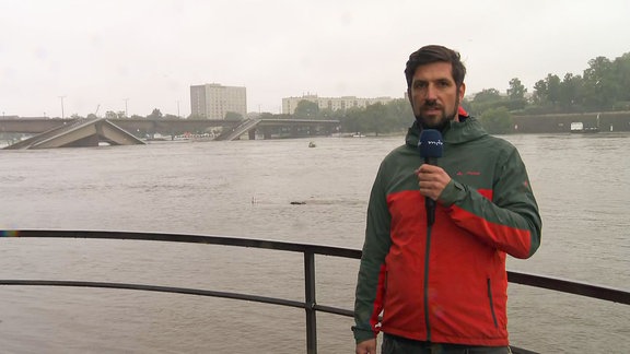 Ein Repoter steht vor der eingestürtzten Carola Brücke