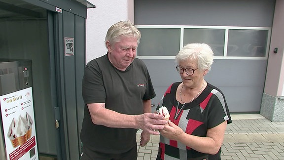 Ein Seniorenpaar übergibt ein Softeis