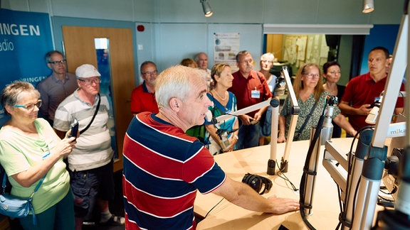 Gruppe von Menschen in einem Radiostudio.