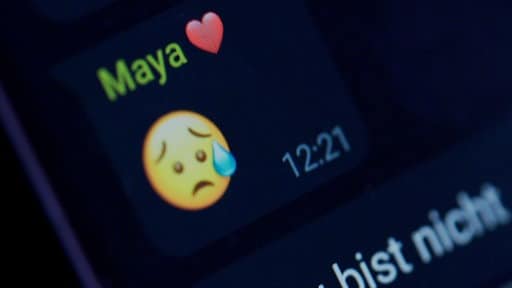 Nahaufnahme eines Smartphone-Bildschirms, auf dem ein Chatverlauf zu sehen, in dem ein weinender Emoji verschickt wurde. | Bildrechte: MDR MEDIEN360G & iStock