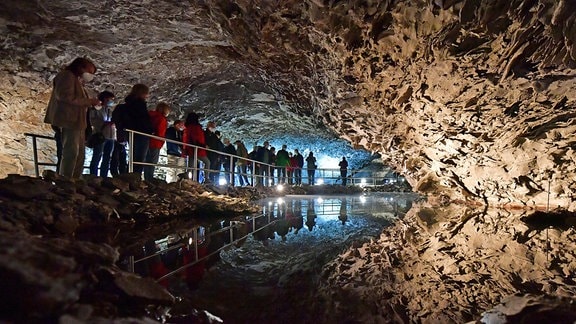 Besucher laufen durch die Barbarossahöhle