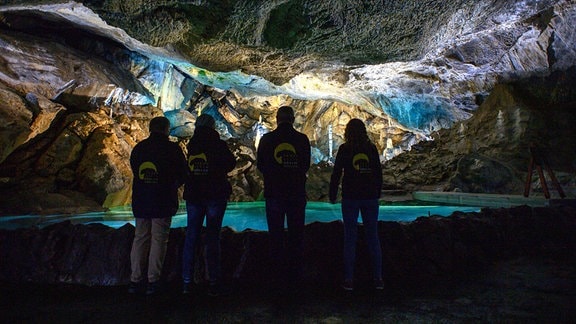 Mitarbeiter vom Tourismusbetrieb Oberharz am Brocken stehen in der Baumannshöhle im sogenannten Göthesaal. 