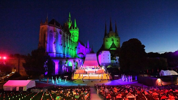 Farbig beleuchtet sind die Bühne, Mariendom und Severikirche für die Domstufen Festspiele in Erfurt