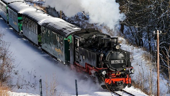 Die Fichtelbergbahn schnauft durch den Winterwald im Erzgebirge