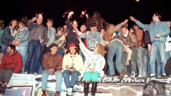 Berlin, 10.11.1989 Mit Wunderkerzen in den Händen freuen sich die Menschen auf der Berliner Mauer über die Öffnung der deutsch-deutschen Grenzen.