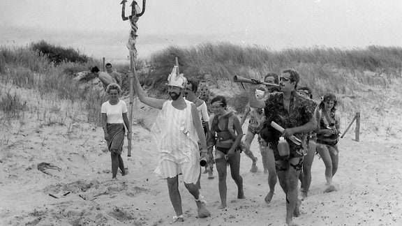 Kostümierte Menschen an einem Strand