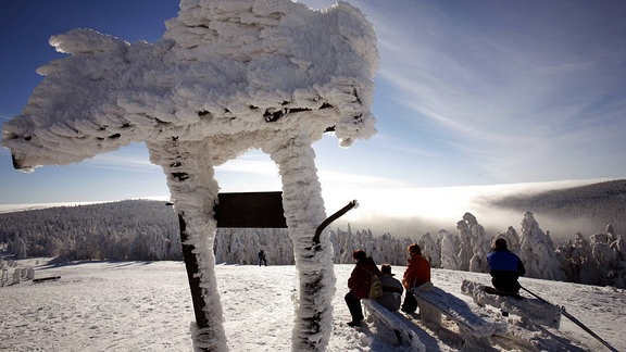 Touristen genießen 2006 die Wintersonne auf dem Schneekopf im Thüringer Wald.