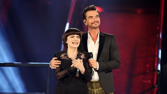 Moderator Florian Silbereisen in Lederhose mit Sängerin Mireille Mathieu