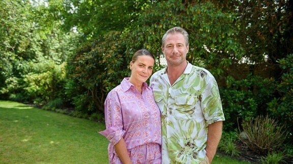 Sänger Sasha und seine Frau Julia Röntgen stehen im Garten ihres Grundstücks. 