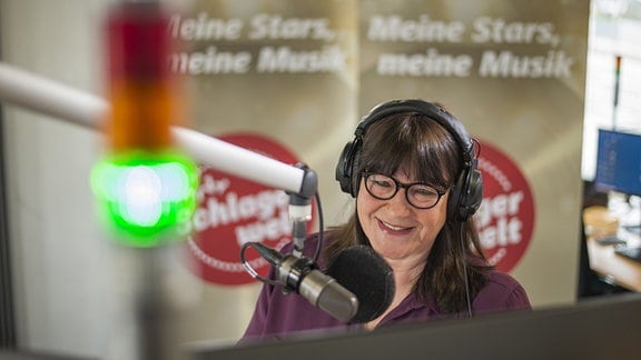 Moderatorin Brigitte Mayer mit Kopfhörern im Studio