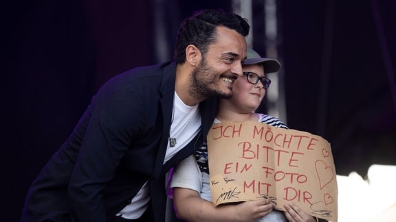 Giovanni Zarella steht in Hildesheim mit einem Fan auf der Bühne.