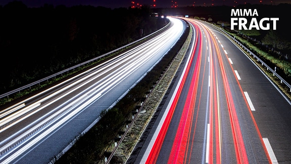Die Lichter von auf der Autobahn fahrenden Autos und LKWs zeichnen durch eine Langzeitbelichtung Lichtspuren in der Fotoaufnahme.