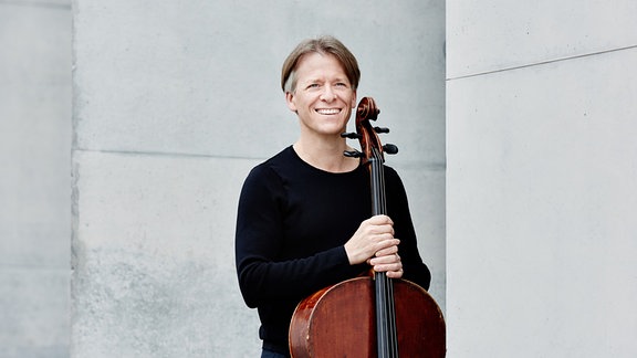 Cellist Alban Gerhardt lächelnd mit seinem Instrument