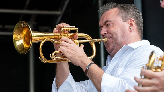 Ein Musiker von German Brass spielt Flügelhorn zum Konzert im Kurpark von Bad Elster