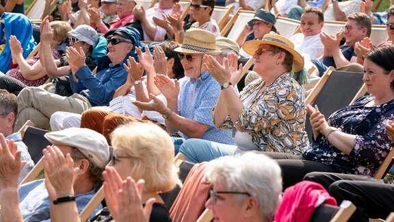 Applaudierendes Publikum auf Liegestühlen beim Konzert von German Brass im Kurpark von Bad Elster