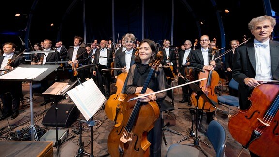Das MDR-Sinfonieorchester nimmt stehend den Schlussapplaus entgegen beim Eröffnungskonzert des MDR-Musiksommers 2023 im Innenhof von Schloss Friedenstein in Gotha