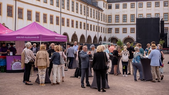 Eröffnungskonzert des MDR-Musiksommers 2023 im Innenhof von Schloss Friedenstein in Gotha: Konzertgäste am Infozelt.