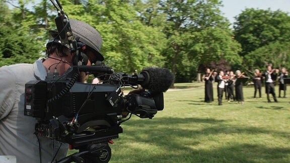 Das MDR-Sinfonieorchester spielt auf dem Rasen des Schlossgartens in Merseburg und wird gefilmt.