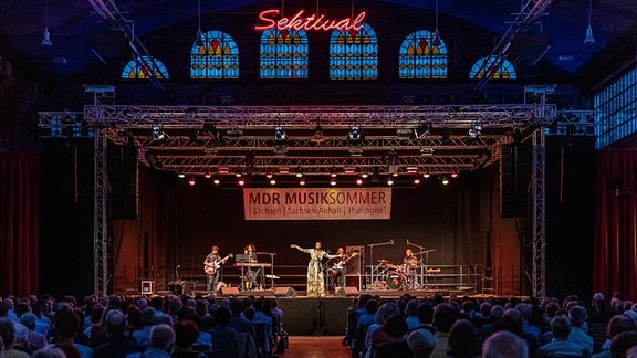 Awa Ly und ihre vier Bandkolleg(inn)en auf der Bühne während des Konzertes in der Rotkäppchen Sektkellerei in Freyburg