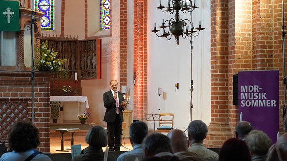 Oliver Jueterbock, Manager des MDR-Musiksommer, begrüßt das Publikum zum Konzert in der Klosterkirche Arendsee.