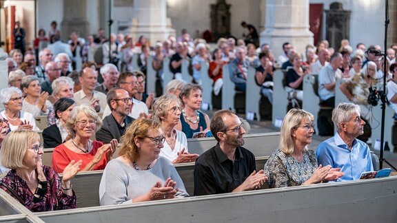 Konzertgäste applaudieren in der Stadtkirche St. Marien beim MDR-Musiksommer 2024 in Torgau