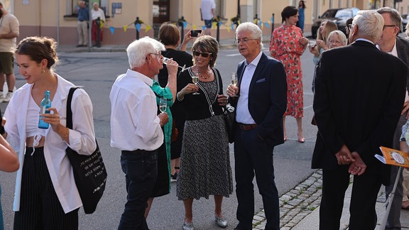 Konzertgäste trinken Sekt vor der St. Marienkirche in Marienberg
