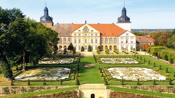 Ein Schloss, umgeben von einem symmetrisch angelegten Garten.