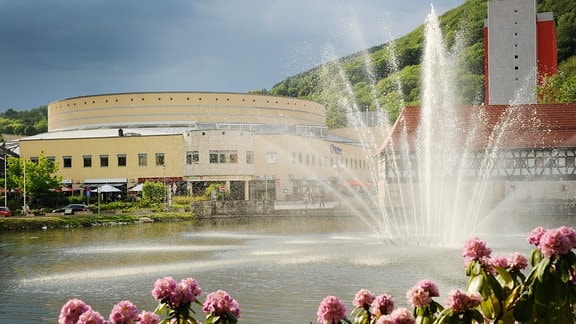 Blick über einen Teich mit Fontäne auf das Congress Centrum in Suhl