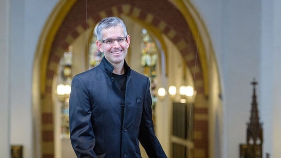 Thomaskantor Andreas Reize lächelnd in der Thomaskirche