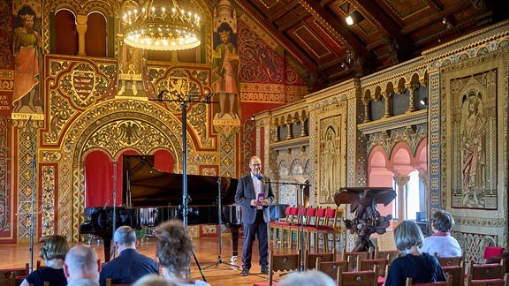 Oliver Jueterbock begrüßt das Publikum beim Konzert des MDR-Musiksommers im prachtvollen Festsaal der Wartburg. 
